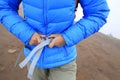 Hiker buckle up the belt of backpack on mountain peak