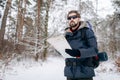 Hiker Checking Map to Orientate in Snow-clad Forest Royalty Free Stock Photo