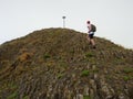 Hiker climbing on sharp peak of basalt formation of volcano Royalty Free Stock Photo