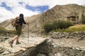 Hiker crossing a bridge in Markha valley, India Royalty Free Stock Photo