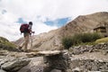 Hiker crossing a bridge in Markha valley, India Royalty Free Stock Photo