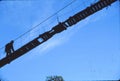 Hiker crossing suspension bridge Royalty Free Stock Photo