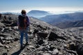 Hiker descending from the top of Mulhacen with mountains and a sea of low clouds in the background Royalty Free Stock Photo