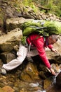 Hiker drinking stream water