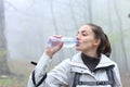 Hiker drinking water from plastic bottle in a forest