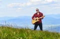 Hiker enjoy nature. Acoustic music. Musician hiker find inspiration in mountains. Keep calm and play guitar. Man hiker Royalty Free Stock Photo