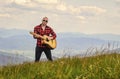 Hiker enjoy nature. Acoustic music. Musician hiker find inspiration in mountains. Keep calm and play guitar. Man hiker Royalty Free Stock Photo