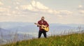 Hiker enjoy nature. Musician hiker find inspiration in mountains. Keep calm and play guitar. Man hiker with guitar on Royalty Free Stock Photo