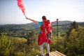 Hiker female holding up torch with smoke