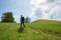 Hiker on footpath to drumlin hill. nature preserve for beautiful wildflowers, relict of the glacial period. spring landscape near