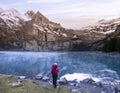 A hiker girl near mountain lake in Switzerland. Lake Oeschinensee in Swiss alps Royalty Free Stock Photo