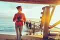 Hiker Girl With Binoculars In Hand Standing By The Sea Near Pier