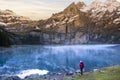 A hiker girl near mountain lake in Switzerland. Lake Oeschinensee in Swiss alps Royalty Free Stock Photo