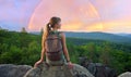 Hiker girl resting on rocky mountain top enjoying morning nature during her travel on wilderness trail. Lonely female Royalty Free Stock Photo