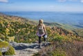 Hiker girl standing on top of mounenjoying scenic fall view. Royalty Free Stock Photo