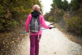 Hiker girl walking on a path in the mountains. Back view of backpacker with pink jacket in a forest. Healthy fitness lifestyle Royalty Free Stock Photo