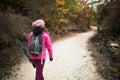 Hiker girl walking on a path in the mountains. Back view of backpacker with pink jacket in a forest. Healthy fitness lifestyle Royalty Free Stock Photo