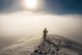 Hiker goes into the fog in winter mountains