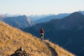 Hiker in high altitude rocky mountain landscape. Summer adventures on the Italian French Alps, toned image. Royalty Free Stock Photo