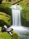 Hiker high boots and sweaty grey socks. Resting on the mossy boulder at the nice mountain stream