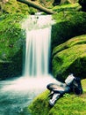 Hiker high boots and sweaty grey socks. Resting on the mossy boulder at the nice mountain stream