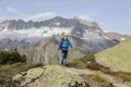 Hiker hikes through a breathtaking alpine landscape in the mountains Royalty Free Stock Photo