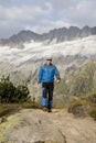 Hiker hikes through a breathtaking alpine landscape in the mountains