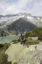 Hiker hikes through a wild high alpine landscape with a lake