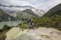 Hiker hikes through a wild high alpine landscape with a lake Royalty Free Stock Photo