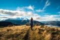 A hiker hiking on the beautiful track with a landscape of the mountains and Lake Wanaka. Roys Peak Track, South Island, New