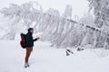 Young man taking photos of a snow covered winter landscape Royalty Free Stock Photo