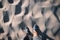 hiker or jogger photographed his feet in shorts and running shoes against the background of sand