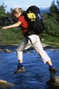 Hiker jumping from rock to rock