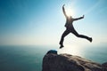 Hiker jumping on sunrise seaside cliff edge Royalty Free Stock Photo