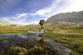 Hiker jumps over creek in sierra nevadas