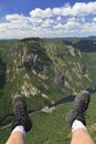 Hiker legs and boots at Acropoles de Draveurs above the Malbaie River, Quebec