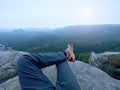 Hiker legs in comfortable trekking boots on rock. Man legs in light outdoor trousers, leather shoes Royalty Free Stock Photo