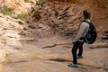 Hiker Looking Down Steep Rock Wash On The Trail To Druid Arch