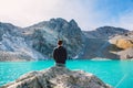 Hiker looks at the mountain lake. Beautiful turquoise lake in the mountains.