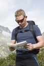 Hiker looks for the right way with the help of a map