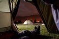 Hiker lying in tent with view of camping, mighty mountains
