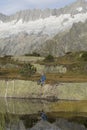 Hiker makes a break at a mountain lake in the Alps