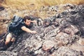 Hiker man climbing natural rocky wall with tropical valley on the background.