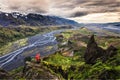 Hiker man in red jacket standing on peak of Valahnukur viewpoint with mountain valley and krossa river in icelandic highlands at