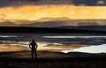 Hiker man silhouette standing at golden sunset over mountains, river and lake. Fantastic view. Iceland. Royalty Free Stock Photo