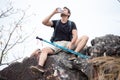 Hiker man take a break on the top mountain drinking water with walking pole . hiking and rest Royalty Free Stock Photo