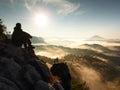 Hiker man take a rest on mountain peak. Man lay on summit, bellow autumn valley. Royalty Free Stock Photo