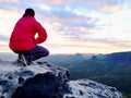 Hiker man take a rest on mountain peak. Man lay on summit, bellow autumn valley. Bright morning Sun Royalty Free Stock Photo