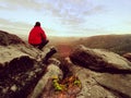 Hiker man take a rest on mountain peak. Man lay on summit, bellow autumn valley Royalty Free Stock Photo