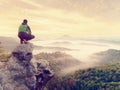 Hiker man take a rest on mountain peak. Man sit on sharp summit and enjoy spectacular view. Royalty Free Stock Photo